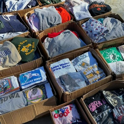 Crates of hand-sorted vintage tees and sweatshirts at the WoodenTimesClub sorting floor