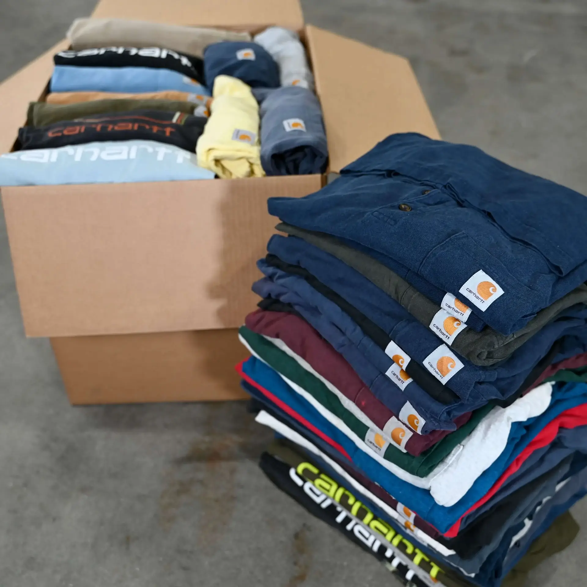 Boxes of hand-sorted vintage Carhartt tees and shirts at the WTC sorting table